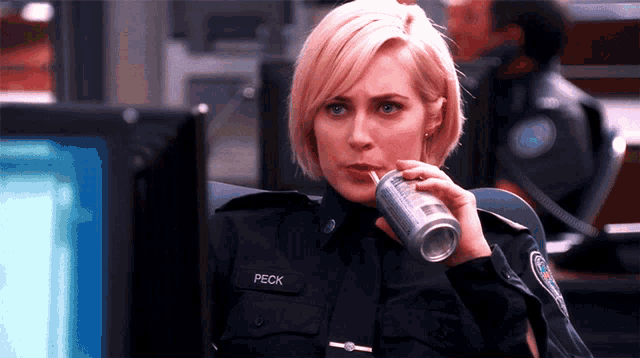 a woman in a police uniform has the name peck on her badge