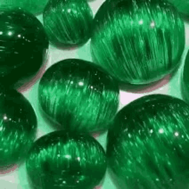 a bunch of green marbles are sitting on a table .