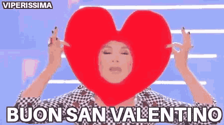 a woman wearing a heart shaped hat is holding a heart in front of her face .