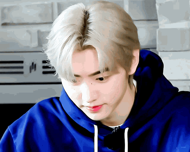 a close up of a person wearing a blue hoodie with the letter e on it