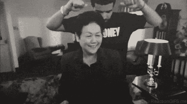 a man in a black shirt with the word honey on it is standing next to a woman