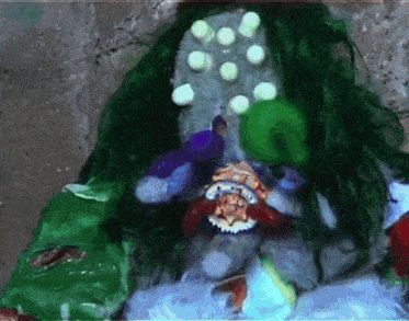 a painting of a clown with green hair and white dots on it