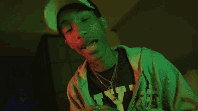 a man wearing a hat and a shirt with the letter y on it looks at the camera