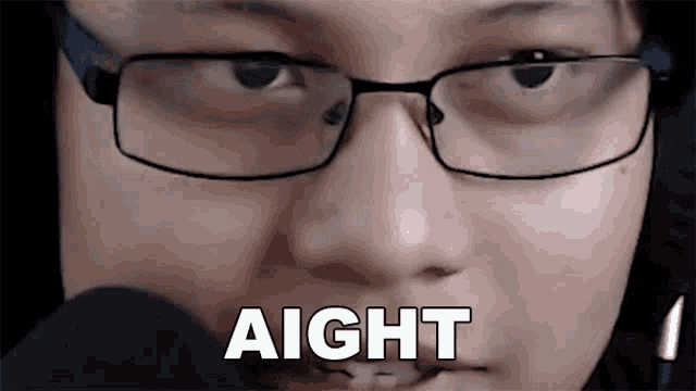 a close up of a person wearing glasses and a microphone with the word aight written on it .