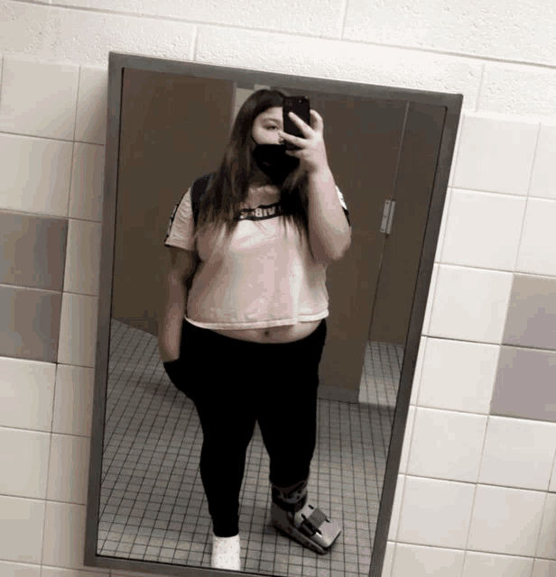a girl taking a picture of herself in a mirror with a shirt that says nike on it