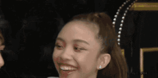 a girl with a ponytail is smiling next to a boy