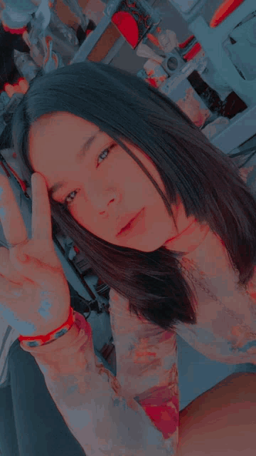 a girl is giving a peace sign with her hand