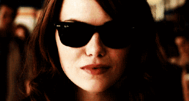 a close up of a woman wearing sunglasses making a funny face