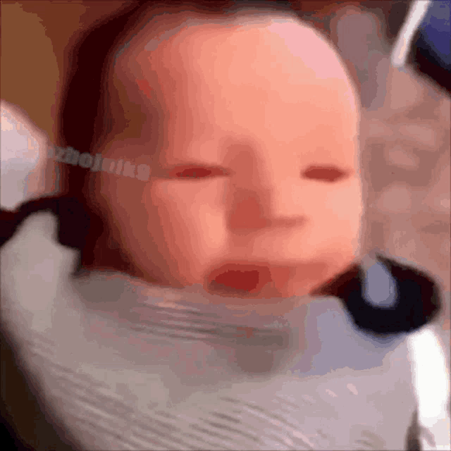 a close up of a baby 's face with a watermark that says ' zhaojunk9 ' at the bottom