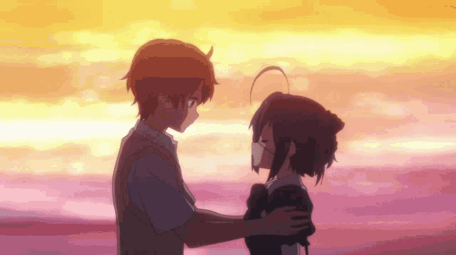 a boy and a girl are hugging each other with a sunset in the background