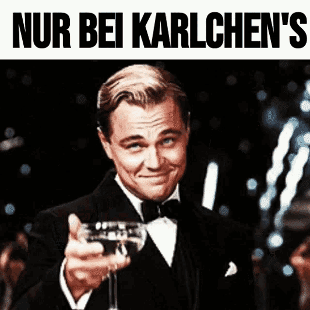 a man in a tuxedo is holding a glass of wine and the words nur bei karlchen 's are above him
