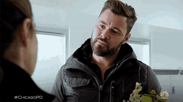 a man with a beard is talking to a woman with #chicagopd on the bottom right