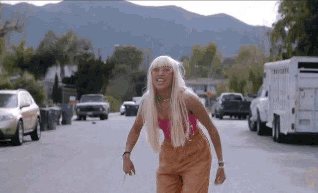 a woman with blonde hair is walking down the street