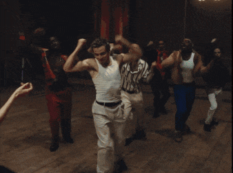 a group of people are dancing together on a wooden floor