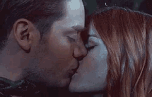 a man and a woman are kissing each other on the forehead .