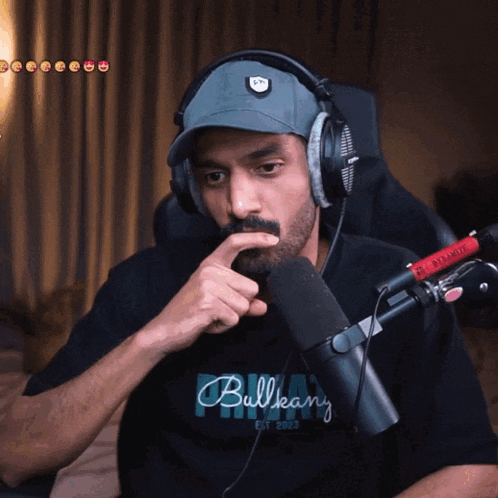 a man wearing headphones and a bullkany shirt