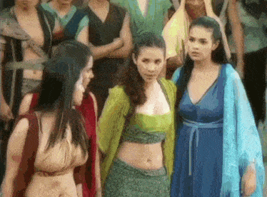 a group of women are standing next to each other in a crowd of people .