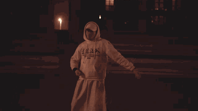 a man wearing a white hoodie with chinese writing on the front