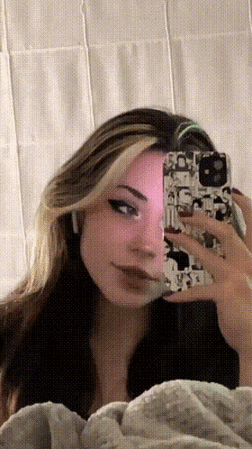 a girl is taking a picture of herself in the mirror with her phone