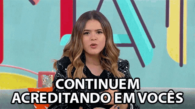 a woman is sitting on a couch with the words continuem acreditando em voces written on the bottom