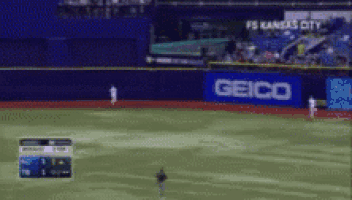 a baseball field with a geico sign on the wall