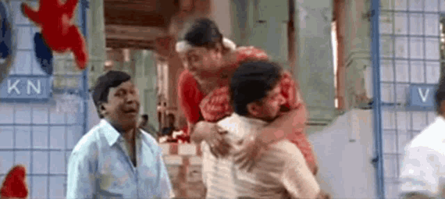a man is carrying a woman on his shoulders in a room .