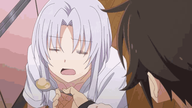 a girl with a spoon in her mouth is being fed by a boy