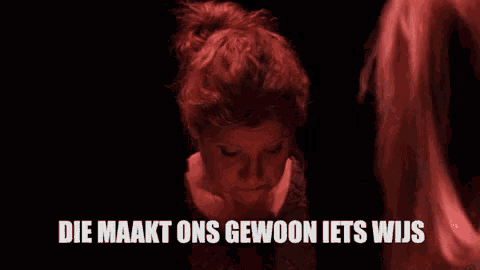 a woman in a dark room with the words die maakt ons gewoon iets wijs written above her
