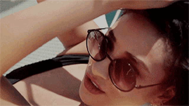 a woman wearing sunglasses and a black bikini
