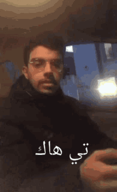 a man in a car with arabic writing on the side of his face
