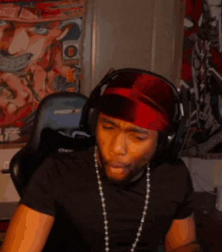 a man wearing headphones and a red headband has the letter o on his head