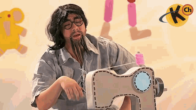 a man with glasses and a beard is using a sewing machine with a kch logo in the background