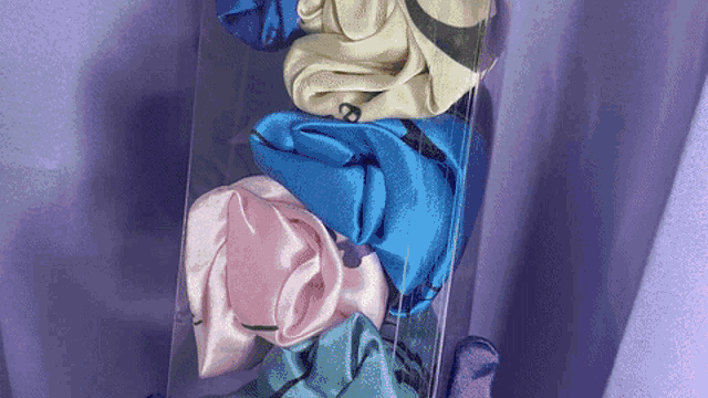 a stack of scrunchies in a clear plastic box