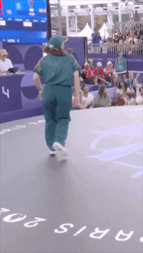a person is dancing in front of a crowd and a sign that says paris 20
