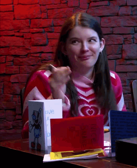 a girl sitting at a table with a card that says juice shake