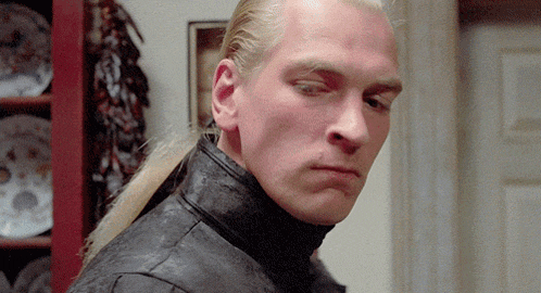 a man with a ponytail is wearing a black jacket