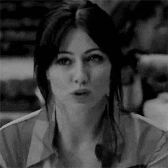 a black and white photo of a woman making a surprised face .