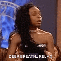 a woman in a strapless dress is sitting in front of a group of people and says `` deep breath , relax '' .