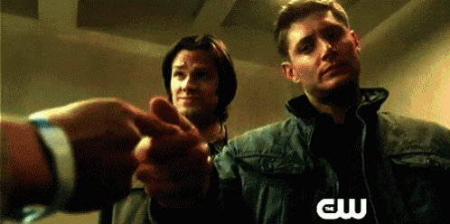 two men shaking hands with a cw logo on the bottom