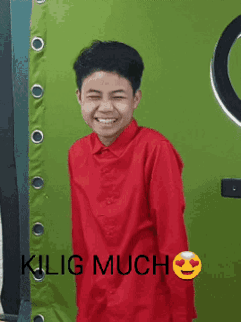 a young boy wearing a red shirt is smiling with the words kilig much above him