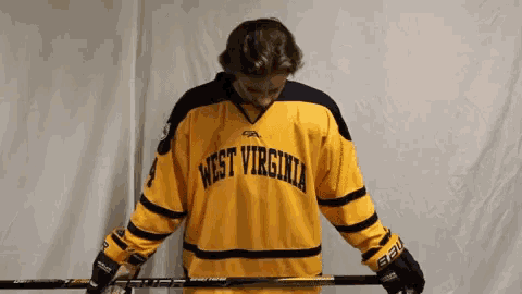 a person wearing a yellow west virginia jersey