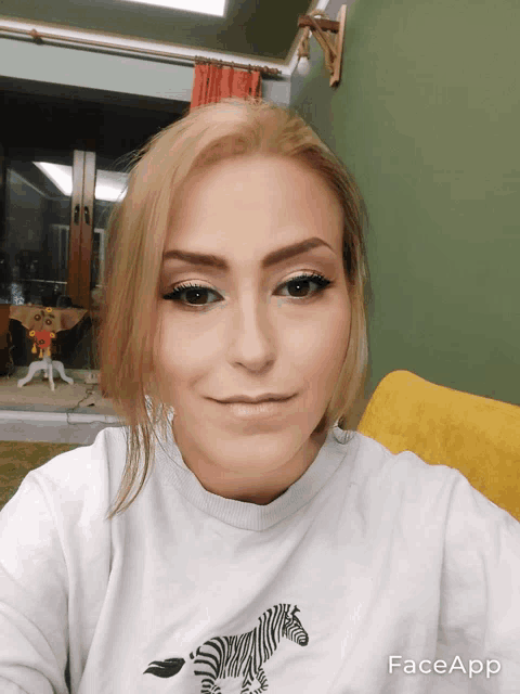 a woman wearing a white shirt with a zebra on it takes a selfie