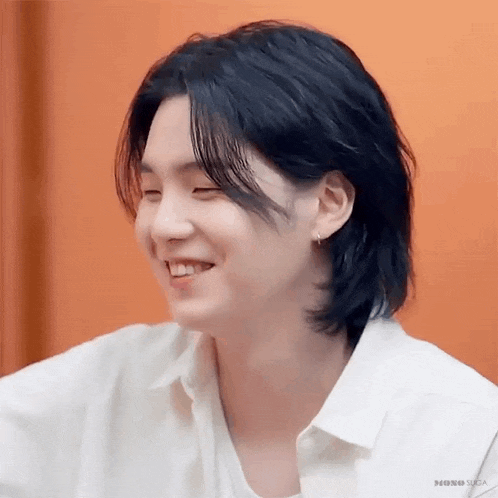 a close up of a person 's face with long black hair and a white shirt .