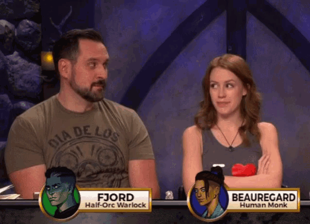 a man and a woman are sitting at a table with their names on them