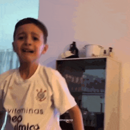 a boy wearing a white shirt that says vitaminas on it