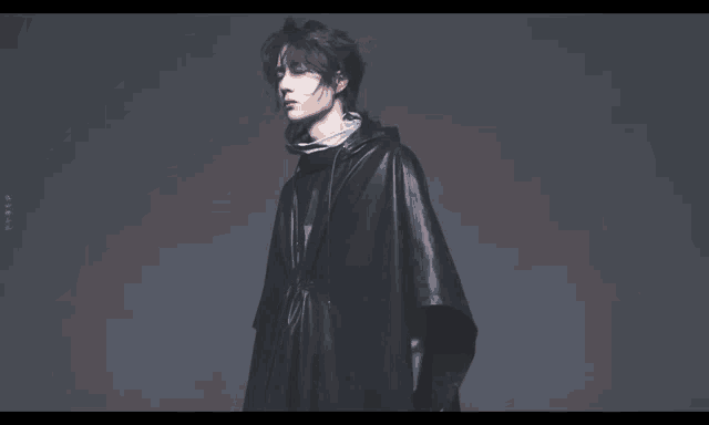 a man with his arms outstretched is wearing a black poncho