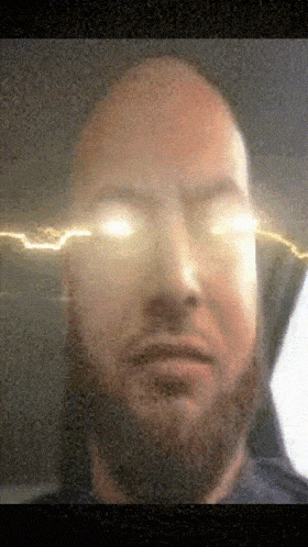 a man with a beard is looking at the camera with lightning coming out of his eyes