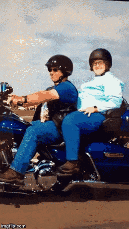 a man and a woman are sitting on a blue harley davidson motorcycle