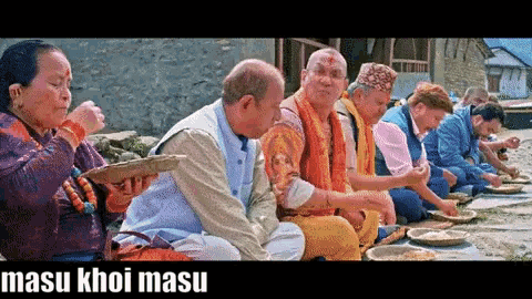 a group of people are sitting on the ground eating food and the words masu khoi masu are on the bottom