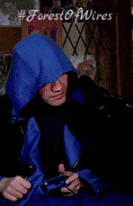 a man in a blue hooded jacket is holding a remote control in his hand
